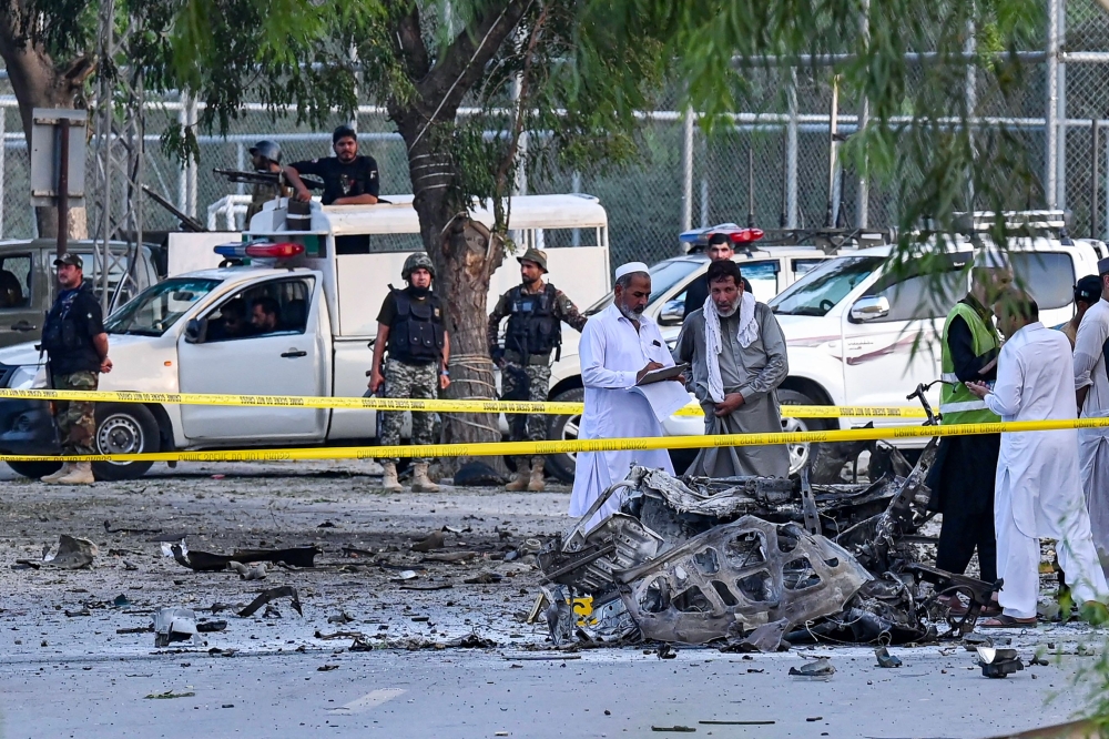 Security personnel gather at the site of the bomb blast in Hayatabad area of Peshawar on July 18, 2023. (Photo by Abdul MAJEED / AFP)
