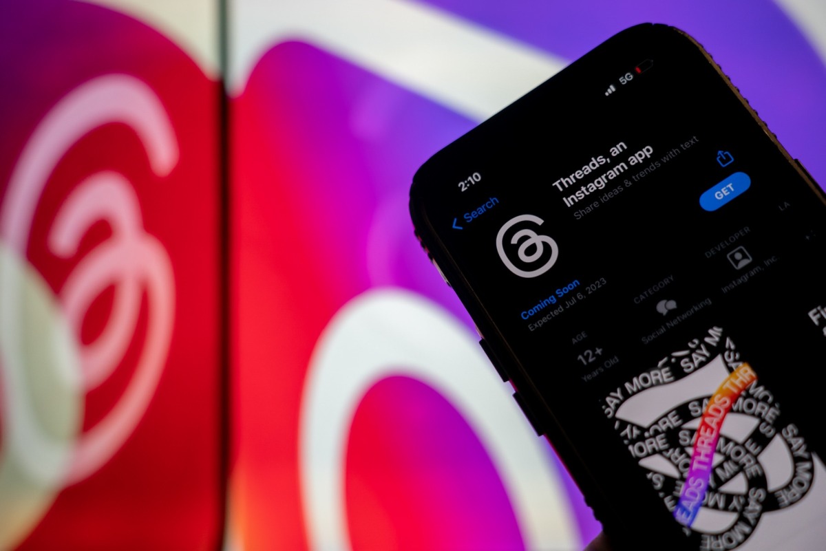 This photo illustration created in Washington, DC, on July 5, 2023, shows Threads, an Instagram app, on the App Store, in front of the logos of Instagram and Threads. (Photo by Stefani Reynolds / AFP)