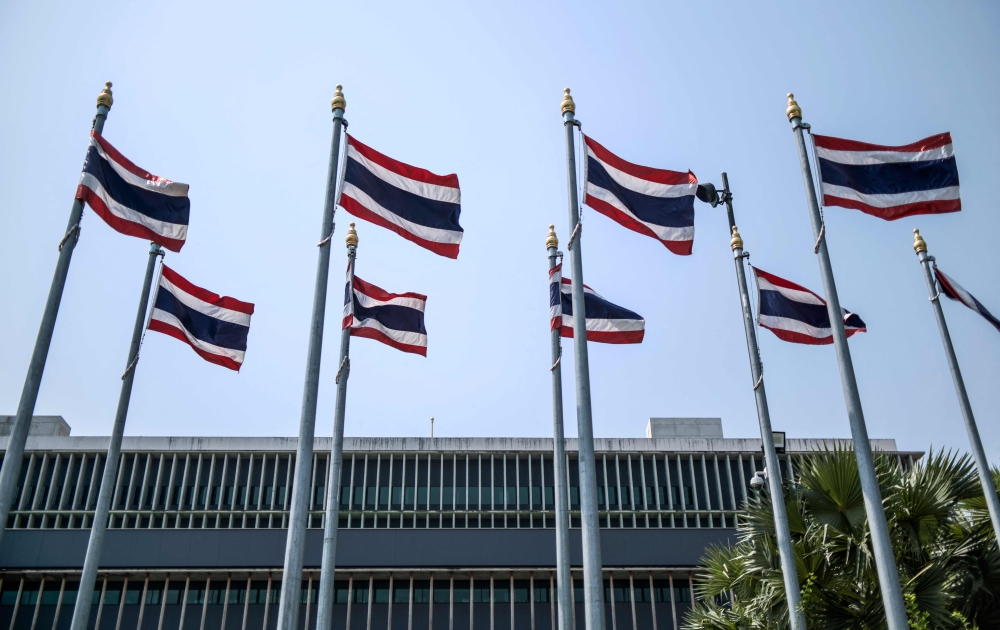 (Files) This file picture taken on March 4, 2023, shows Thai national flags on the side of the Parliament complex in Bangkok, the meeting place of the National Assembly of Thailand. (Photo by Amaury Paul / AFP)

