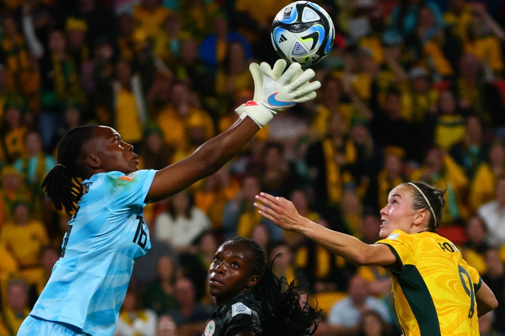 Nigeria's goalkeeper #16 Chiamaka Nnadozie (L) makes a save during the Australia and New Zealand 2023 Women's World Cup Group B football match between Australia and Nigeria at Brisbane Stadium in Brisbane on July 27, 2023. (Photo by Patrick Hamilton / AFP)