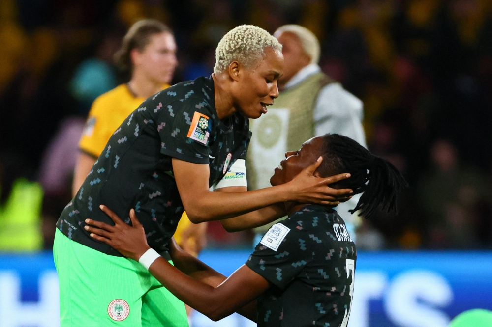Nigeria's defender #05 Onome Ebi (L) and Nigeria's defender #03 Osinachi Ohale celebrate their team's victory after the end of the Australia and New Zealand 2023 Women's World Cup Group B football match between Australia and Nigeria at Brisbane Stadium in Brisbane on July 27, 2023. (Photo by Patrick Hamilton / AFP)
