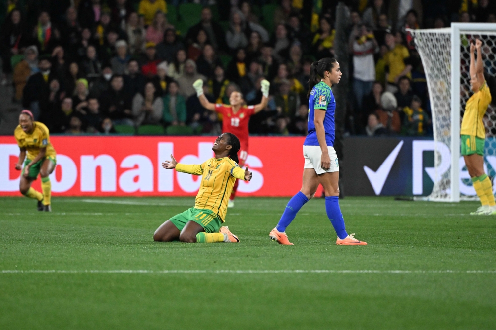 Brazil's defender #04 Rafaelle (2nd R) walks past as Jamaica's players celebrate qualifying for the last 16 in Melbourne on August 2, 2023. (Photo by William West / AFP)