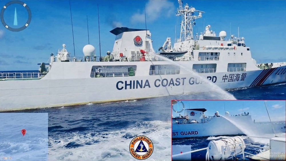 This undated handout released by the Philippine Coast Guard (PCG) on August 6, 2023 shows a China Coast Guard ship (L) releasing water cannon on a Philippine Coast Guard ship near Second Thomas Shoal during a re-supply mission on August 5. (Photo by Handout / Philippine Coast Guard (PCG) / AFP)