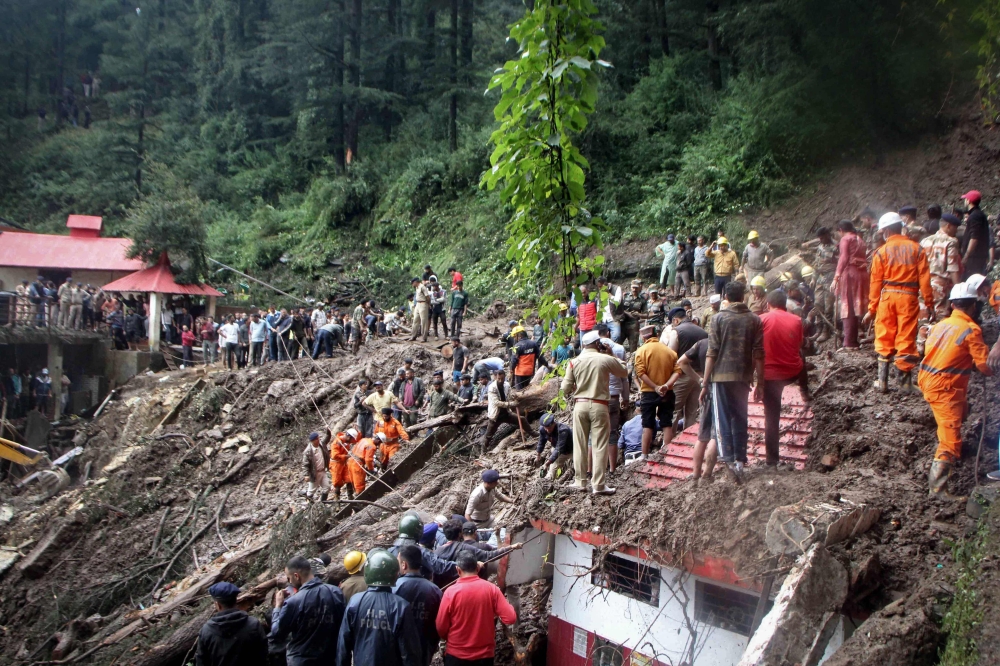 National Disaster Response Force (NDRF) personnel search for victims at the site of a landslide after a temple collapsed due to heavy rains in Shimla on August 14, 2023. Photo by AFP