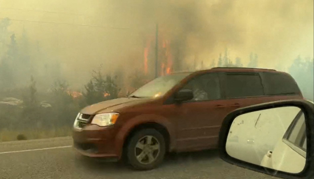 This screengrab from a video provided by Jordan Straker shows vehicles driving on the freeway as people evacuate from Yellowkife, Northwest Territories, Canada, on August 16, 2023. (Photo by Jordan Straker / UGC / AFP)