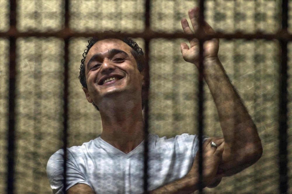(FILES) Egyptian political activist Ahmed Douma reacts as he stands behind dock bars during his trial in Cairo on June 3, 2013, on charges of insulting president Mohamed Morsi. (Photo by Khaled DESOUKI / AFP)
