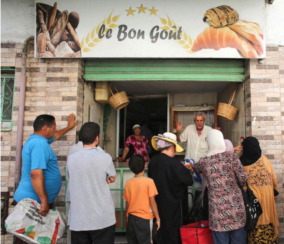 People queue in front of a bakery selling subsidised bread in Tunis' Halfaouine district, on August 19, 2023. (Photo by HASNA / AFP)