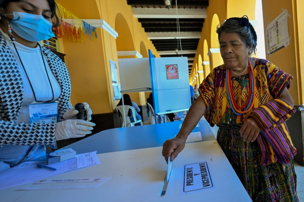 An Indigenous woman casts her vote at a polling station in the municipality of San Juan Sacatepequez, during the Guatemalan presidential run-off election on August 20, 2023. (Photo by Luis Acosta / AFP)
