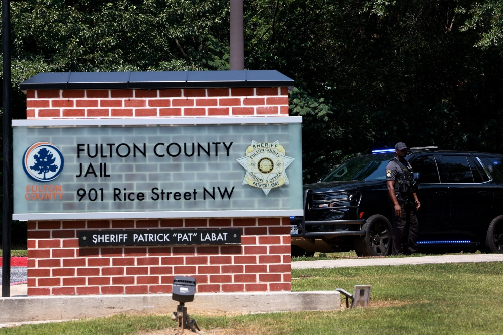 A Fulton County Sheriff officer stands at an entrance to the Fulton County Jail on August 22, 2023 in Atlanta, Georgia. Joe Raedle/Getty Images/AFP 
