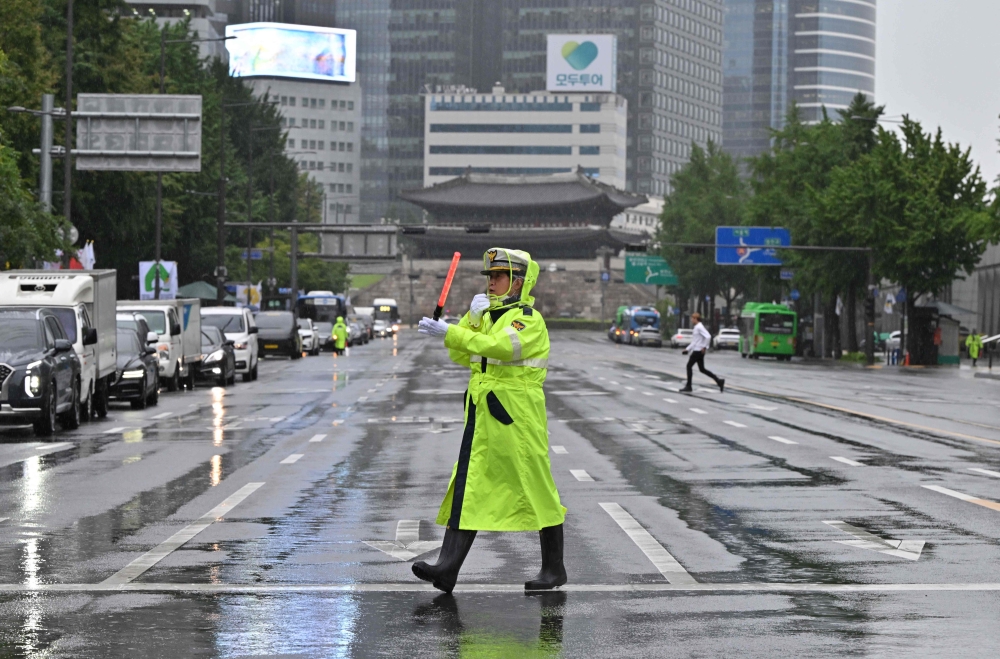 A police officer controls traffic on an empty street during a civil defence drill against possible artillery attacks by North Korea in Seoul on August 23, 2023. Photo by Jung Yeon-je / AFP