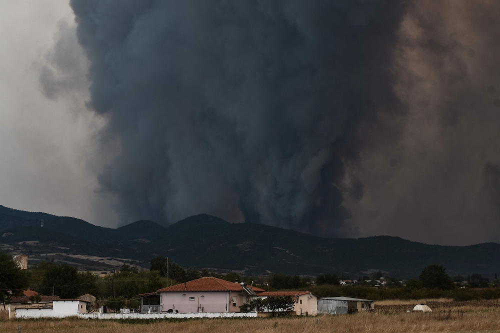 Smoke billows from a forest as wildfire rages in Kasiteres near Komotini, on August 23, 2023. (Photo by Sakis Mitrolidis / AFP)