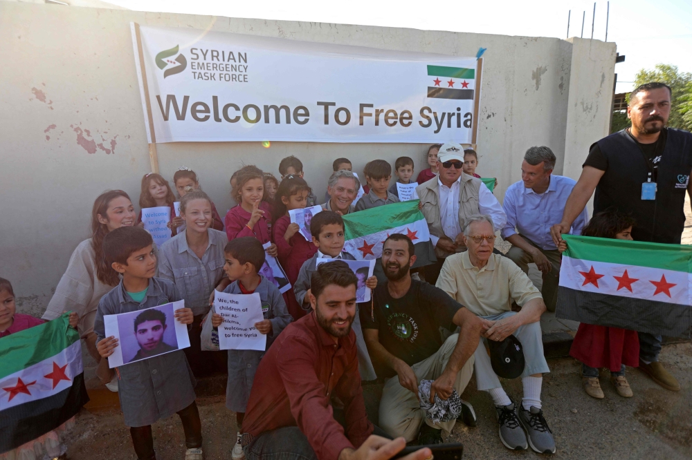 A delegation of US representatives poses for a picture with orphaned children during their visit to a hospital in Syria's border town of Azaz, in the north of Aleppo province, on August 27, 2023. (Photo by Bakr Alkasem / AFP)