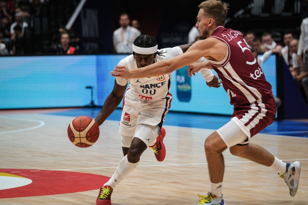 France's Sylvain Francisco (L) dribbles the ball as Latvia's Arturs Zagars tries to block during the FIBA Basketball World Cup group G match between France and Latvia at Indonesia Arena in Jakarta on August 27, 2023. (Photo by Yasuyoshi CHIBA / AFP)
