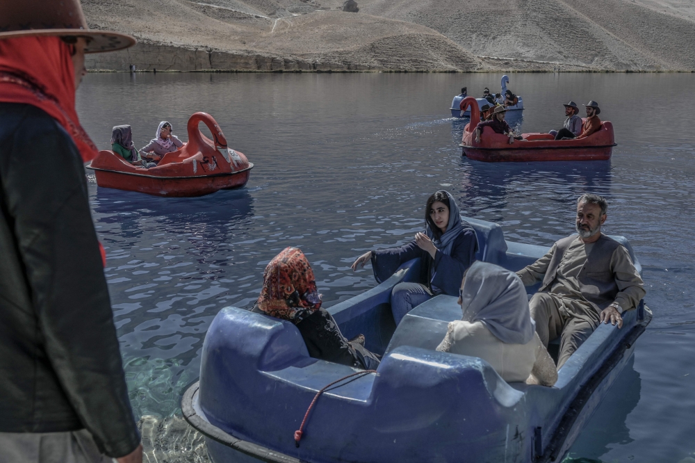 People sit on paddle boats for a ride at the Band e-Amir lake in the Bamiyan Province on October 4, 2021. (Photo by Bulent Kilic / AFP) / XGTY