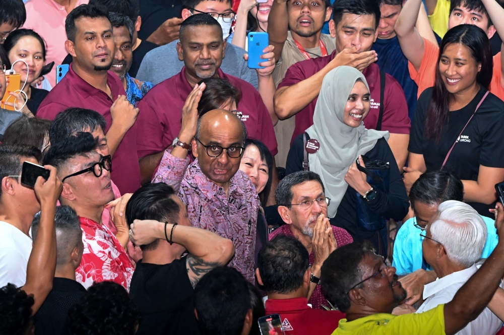 Presidential candidate Tharman Shanmugaratnam (centre) meets his supporters while waiting for the Presidential election results in Singapore on September 1, 2023. (Photo by Roslan RAHMAN / AFP)
