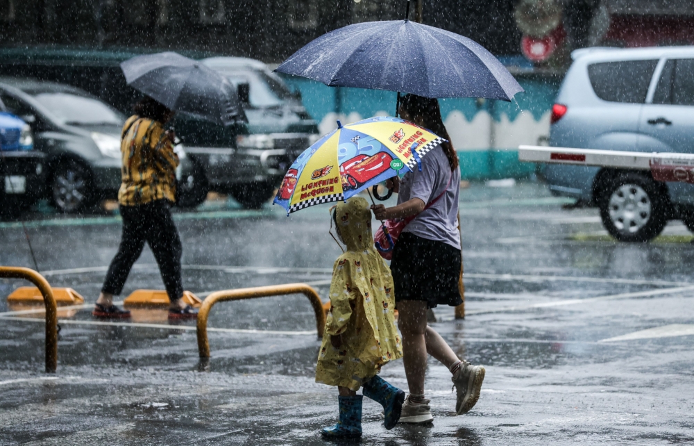 People hold umbrellas while walking on the street in the rain in Keelung after Typhoon Haikui hits Taiwan on September 4, 2023. (Photo by I-Hwa Cheng / AFP)