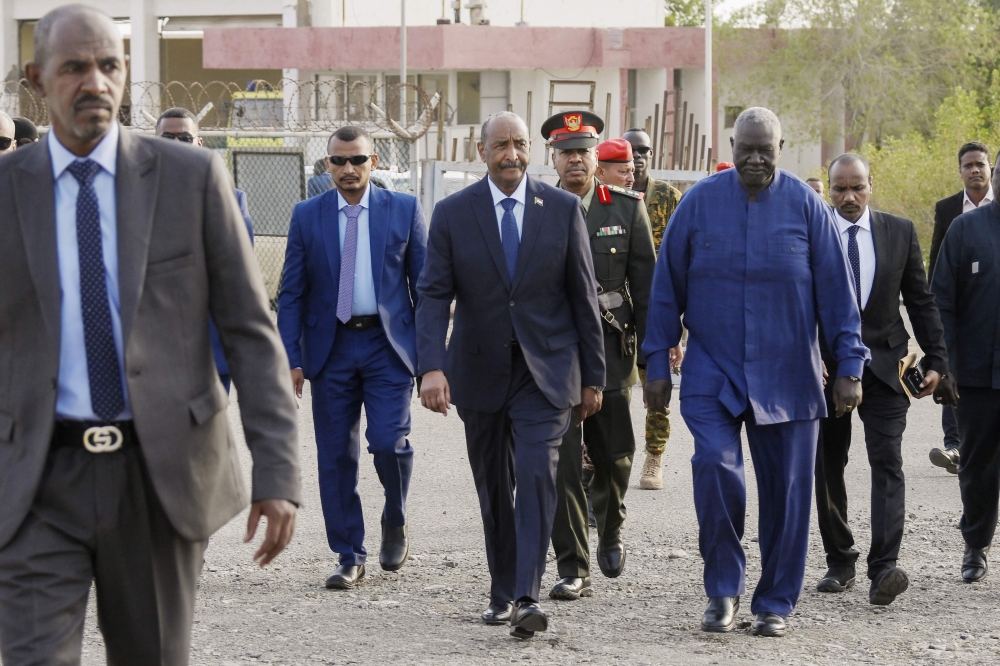 President of Sudan's Transitional Sovereignty Council (TSC) General Abdel Fattah al-Burhan (centre) arrives to board an airplane at Port Sudan airport, heading to South Sudan, on September 4, 2023. (Photo by AFP)