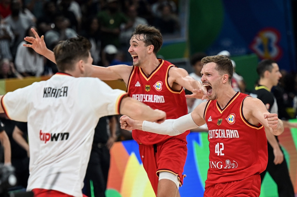 Team Germany celebrates their victory during the FIBA Basketball World Cup semi-final match between USA and Germany in Manila on September 8, 2023. (Photo by Jam Sta Rosa / AFP)