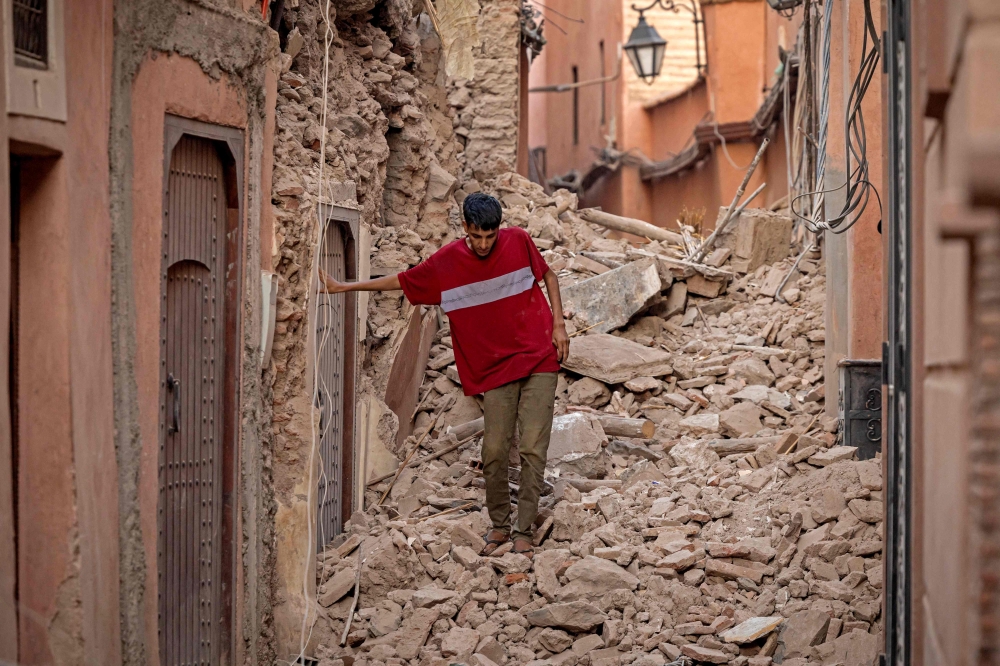 A resident navigates through the rubble following a 6.8-magnitude quake in Marrakesh on September 9, 2023. (Photo by FADEL SENNA / AFP)
