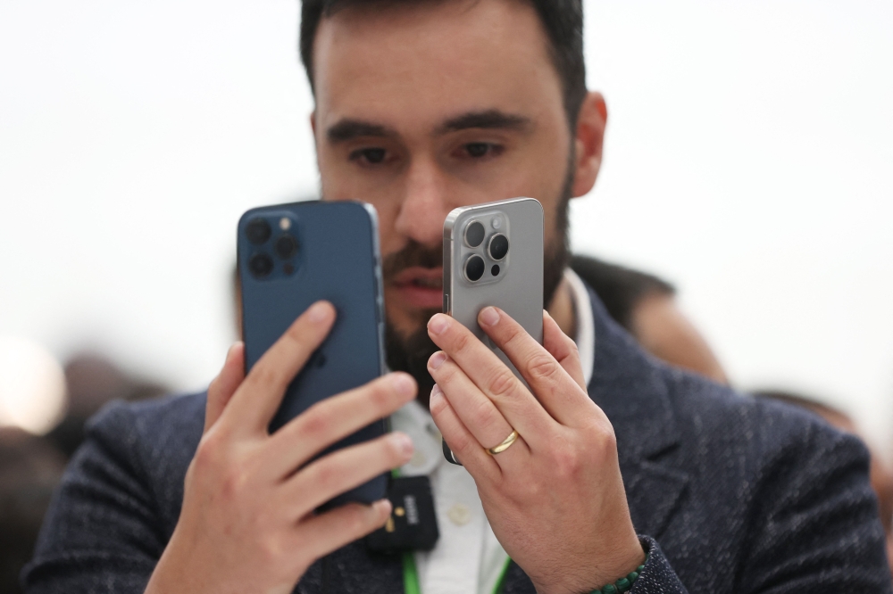 An attendee looks at the brand new Apple iPhone 15 Pro and iPhone 15 Pro Max products during an Apple event on September 12, 2023 in Cupertino, California. Photo by JUSTIN SULLIVAN / GETTY IMAGES NORTH AMERICA / Getty Images via AFP