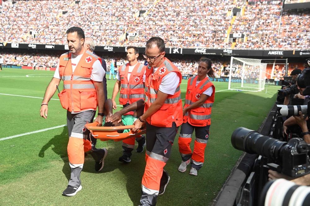 Atletico Madrid's French midfielder #11 Thomas Lemar is evacuated on a stretcher during the Spanish Liga football match between Valencia CF and Club Atletico de Madrid at the Mestalla stadium in Valencia on September 16, 2023. (Photo by JOSE JORDAN / AFP)
