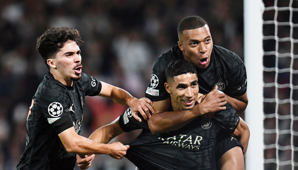 PSG’s Achraf Hakimi (centre) celebrates with teammates Kylian Mbappe (right) and Vitinha after scoring a goal against Borussia Dortmund in Paris, yesterday. AFP
