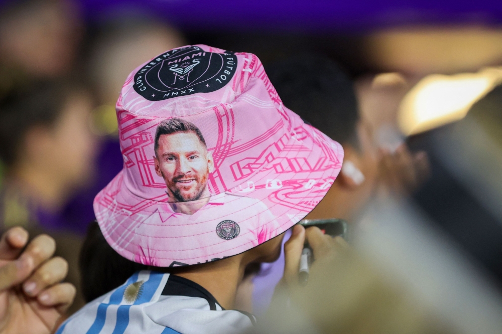 A fan wears a Lionel Messi bucket hat against during the game between the Inter Miami CF and the Orlando City SC during the second half at Exploria Stadium on September 24, 2023 in Orlando, Florida. (Photo by Alex Menendez / GETTY IMAGES NORTH AMERICA / Getty Images via AFP)
