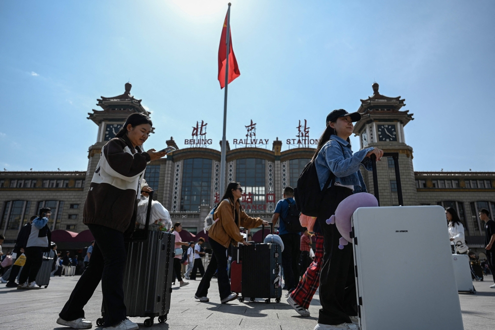 Passengers arrive at Beijing railway station on the first day of peak travel ahead of the National Day holidays in China's capital city on September 29, 2023. Photo by Jade GAO / AFP