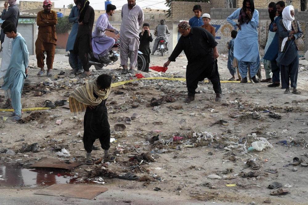 People gather at the site of a suicide bomb attack that targeted a religious gathering in Mastung district in Pakistan's Balochistan province on September 29, 2023.  (Photo by Banaras Khan / AFP)

