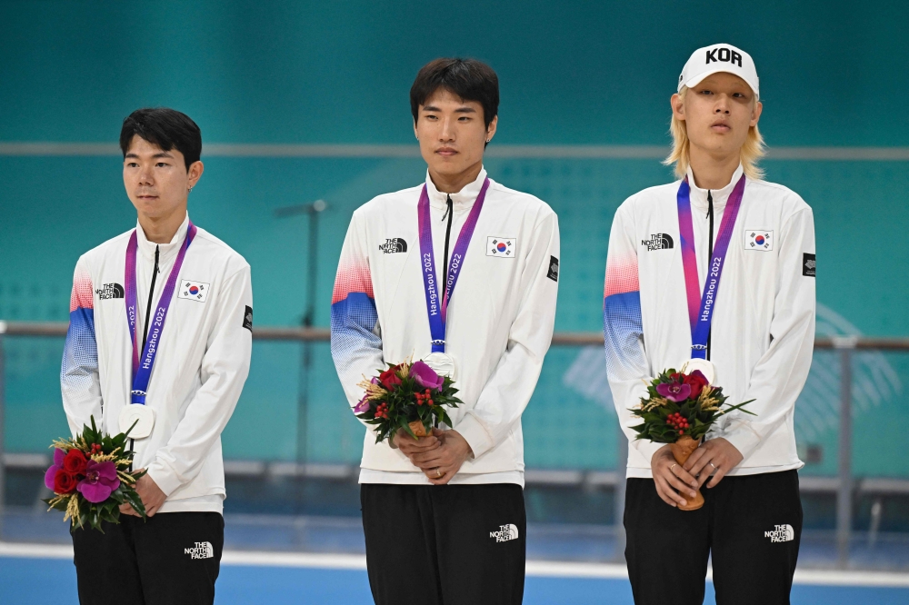 Silver medallists South Korea's Jung Cheol-won, Choi In-ho and Choi Gwang-ho attend the awards ceremony of the men's 3000m relay speed skating event during the 2022 Asian Games in Hangzhou in China's eastern Zhejiang province on Octorber 2, 2023. (Photo by WANG Zhao / AFP)