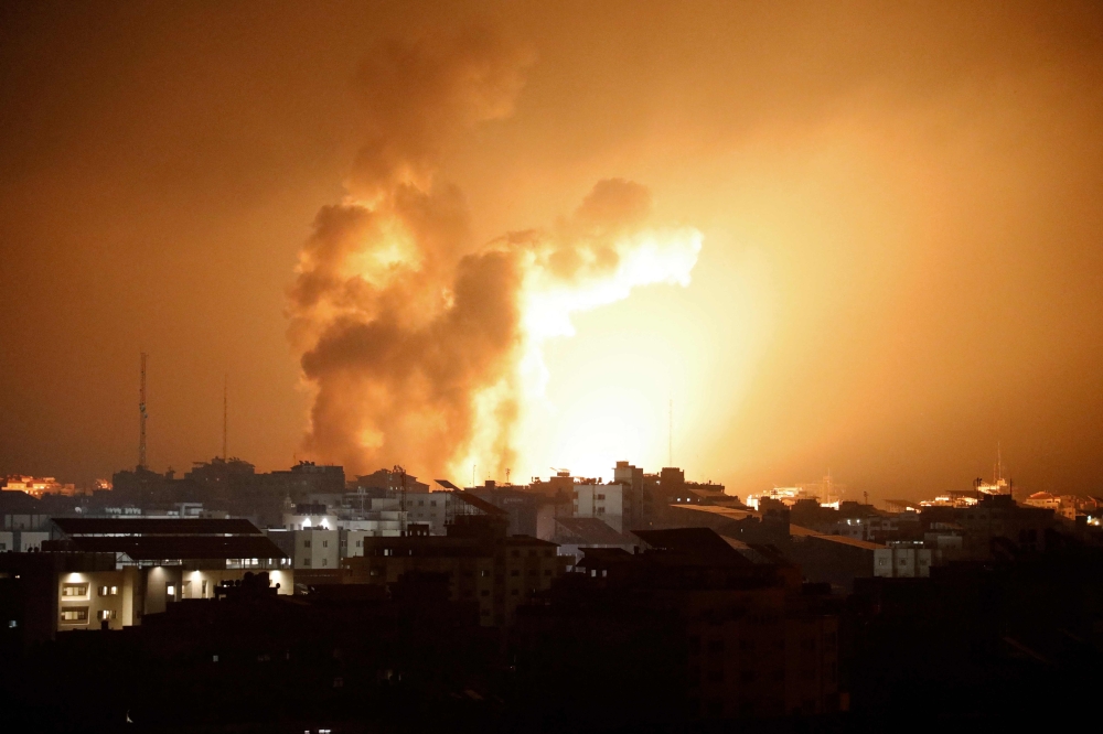 Fire and smoke rises above buildings during an Israeli air strike in Gaza City on October 8, 2023. (Photo by Eyad Baba / AFP)