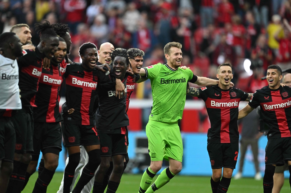 Leverkusen players celebrate after the German first division Bundesliga football match between Bayer 04 Leverkusen and FC Cologne in Leverkusen, western Germany on October 8, 2023. (Photo by INA FASSBENDER / AFP)