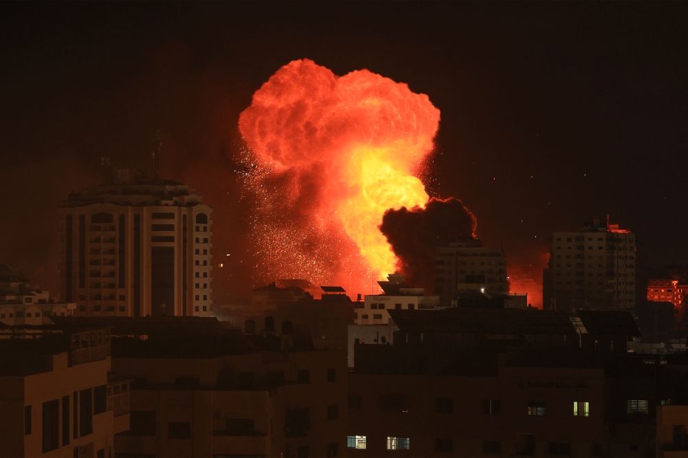 A fireball erupts during Israeli bombardment of Gaza City on October 9, 2023. (Photo by MAHMUD HAMS / AFP)
