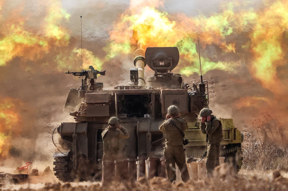 An Israeli army self-propelled howitzer fires rounds near the border with Gaza in southern Israel on October 11, 2023. (Photo by Jack Guez / AFP)