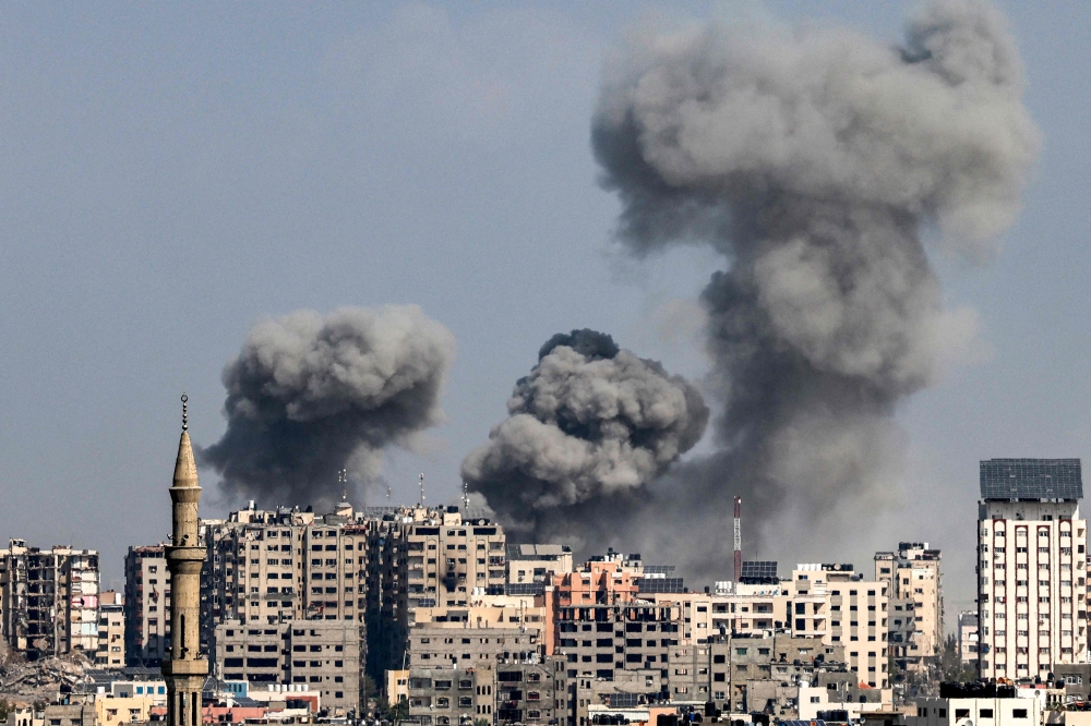 Smoke plumes billow during Israeli air strikes in Gaza City on October 12, 2023. (Photo by Mohammed Abed / AFP)
