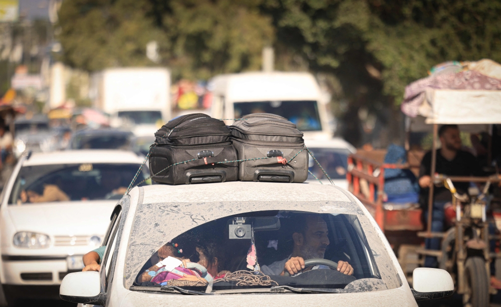 Palestinians with their belongings flee northern Gaza City following the Israeli army's warning to leave their homes before an expected ground offensive, in Gaza City on October 13, 2023. (Photo by Mahmud Hams / AFP)