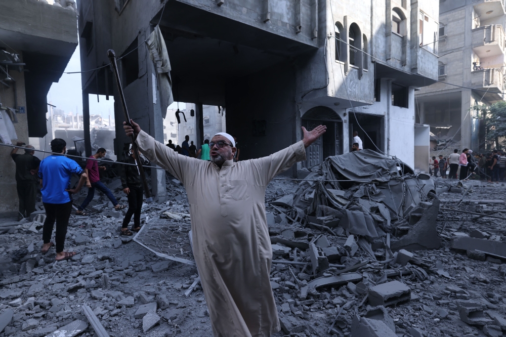 A Palestinian reacts amidst the rubble of a building after an Israeli airstrike on the Rafah refugee camp, in the southern Gaza Strip on October 17, 2023. (Photo by Mohammed Abed / AFP)