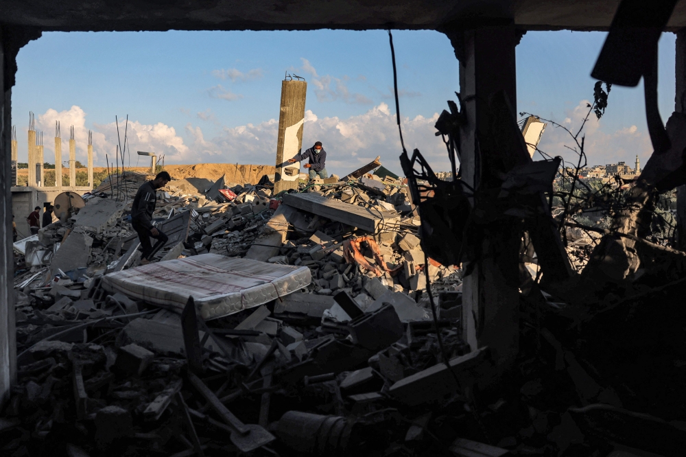 People search through the rubble of a destroyed building following Israeli bombardment in Rafah in the southern of Gaza Strip on October 19, 2023. Photo by MOHAMMED ABED / AFP
