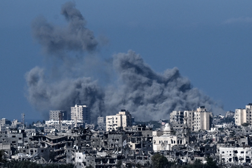 Smoke rising behind destroyed buildings in the north-western part of the Palestine during an Israeli bombing on October 21, 2023. (Photo by Aris Messinis / AFP)