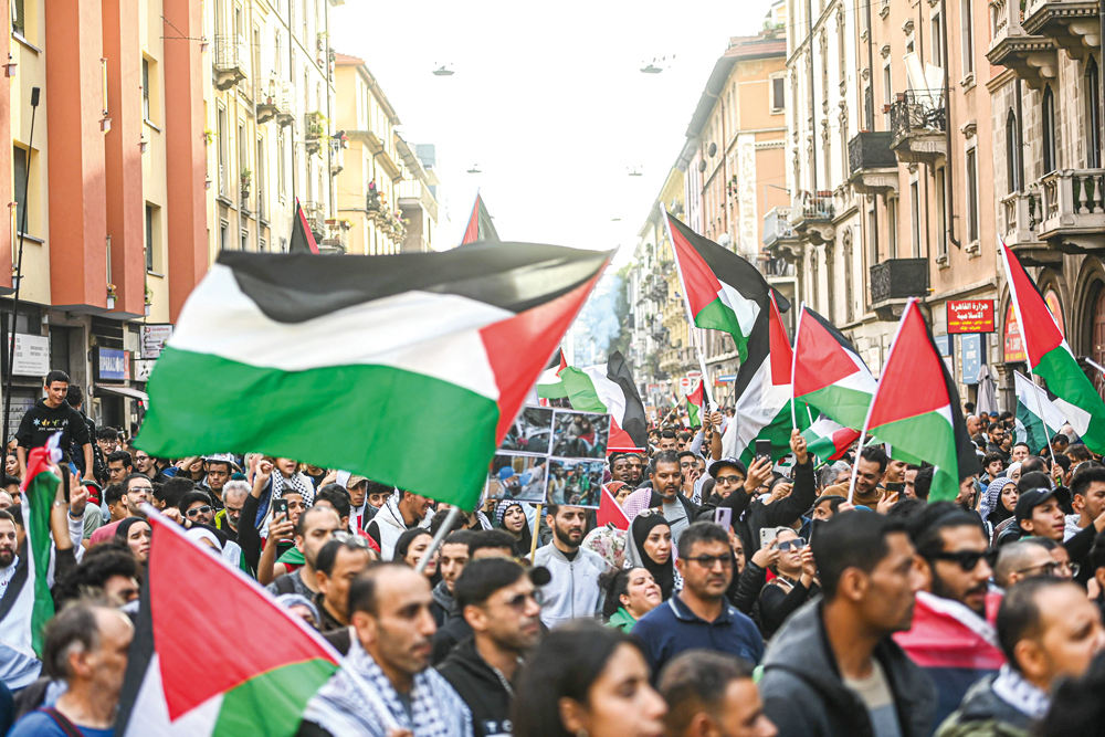 People wave flags as they march during a demonstration in support of Palestinians in Milan yesterday.