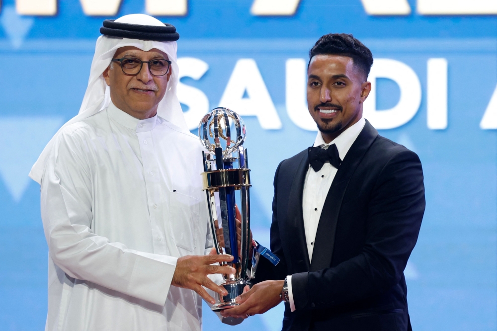 President of the Asian Football Confederation (AFC) Shaikh Salman bin Ibrahim al-Khalifa (L) presents Saudi Arabia's forward Salem al-Dawsari with the AFC Player of the Year award during the AFC Annual Awards Doha 2022 on October 31, 2023. (Photo by KARIM JAAFAR / AFP)
