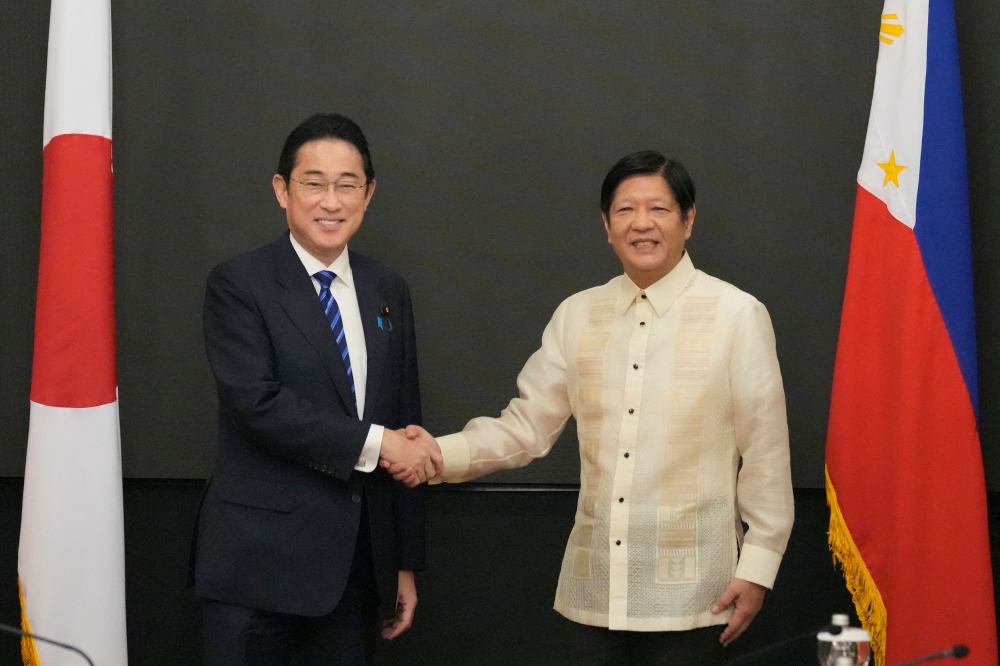 Philippine President Ferdinand Marcos Jr. (right) shakes hands with Japanese Prime Minister Fumio Kishida at the Malacanang presidential palace in Manila on November 3, 2023. (Photo by Aaron Favila / POOL / AFP)
