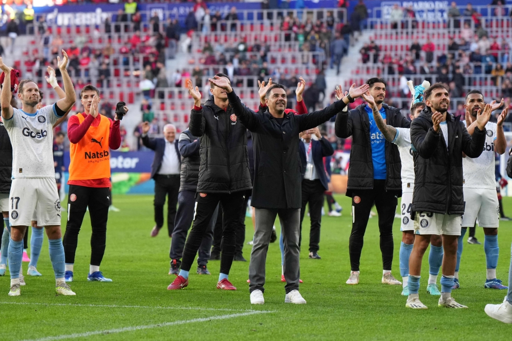 Girona's Spanish coach Michel (C) and teammates celebrate their win at the end of the Spanish league football match between CA Osasuna and Girona FC at El Sadar stadium in Pamplona on November 4, 2023. (Photo by Cesar MANSO / AFP)
