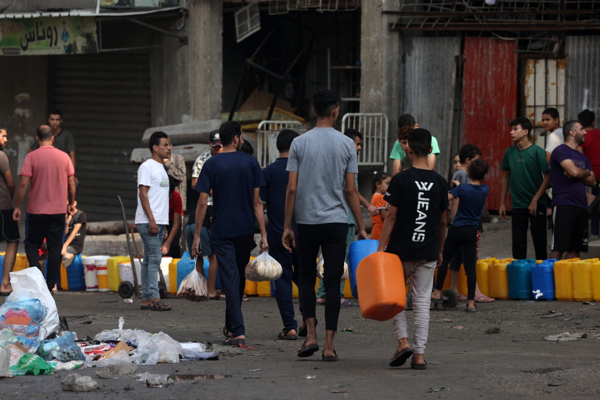 People queue for fresh water in the aftermath of Israeli strikes in Gaza City on October 28, 2023. Photo by MOHAMMED ABED / AFP