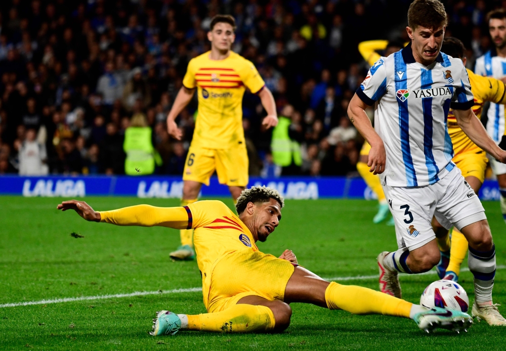 Barcelona's Uruguayan defender #04 Ronald Araujo vies with Real Sociedad's Spanish defender #03 Aihen Munoz during the Spanish league football match in San Sebastian on November 4, 2023. (Photo by Ander Gillenea / AFP)