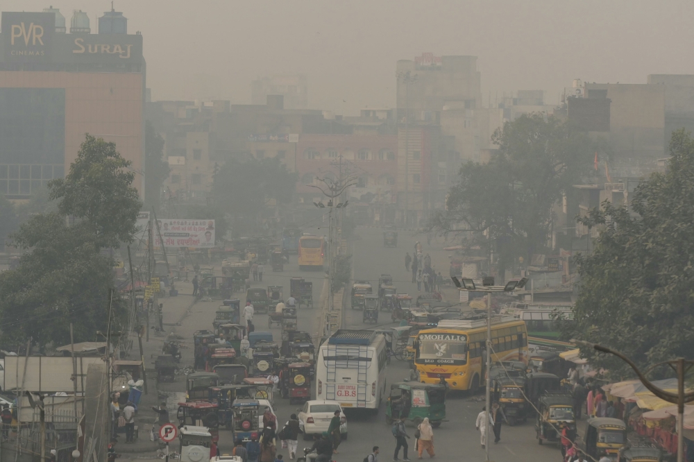 Commuters make their way along a road amid heavy smoggy conditions in Amritsar on November 6, 2023. Photo by Narinder NANU / AFP