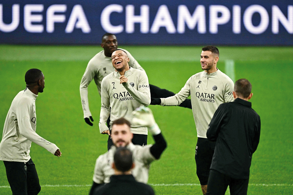 PSG's Kylian Mbappe with Lucas Hernandez (right) and teammates during a training session on the eve of the match against AC Milan, yesterday. AFP