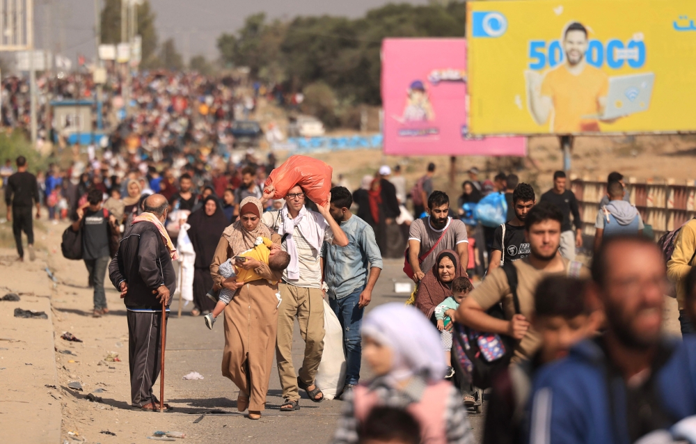 Palestinian families fleeing Gaza City and other parts of northern Gaza towards the southern areas, walk along a highway on November 9, 2023. (Photo by Mahmud Hams / AFP)