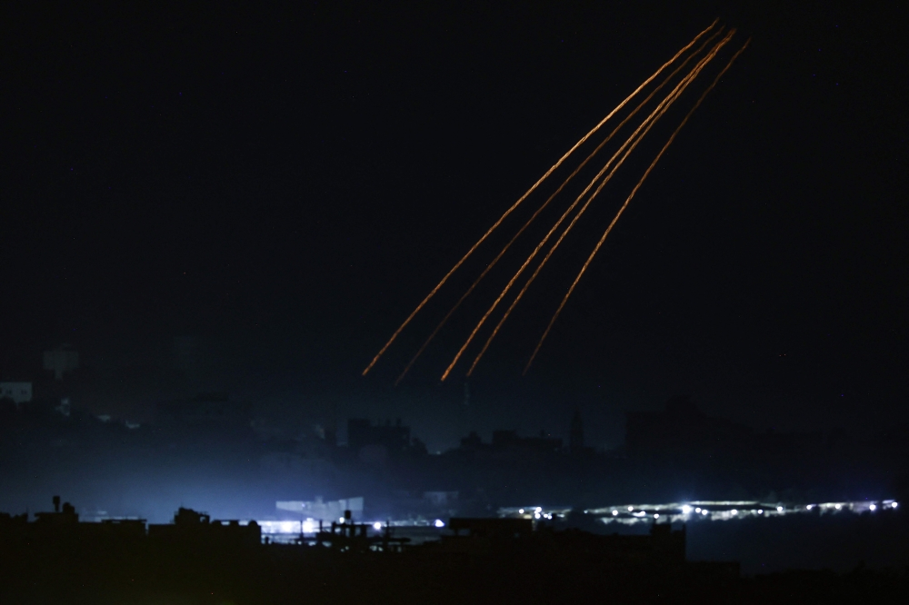 This picture taken from the Israeli side of the border with Gaza on November 10, 2023, shows Israeli flares over the Gaza Strip. (Photo by Kenzo Tribouillard / AFP)