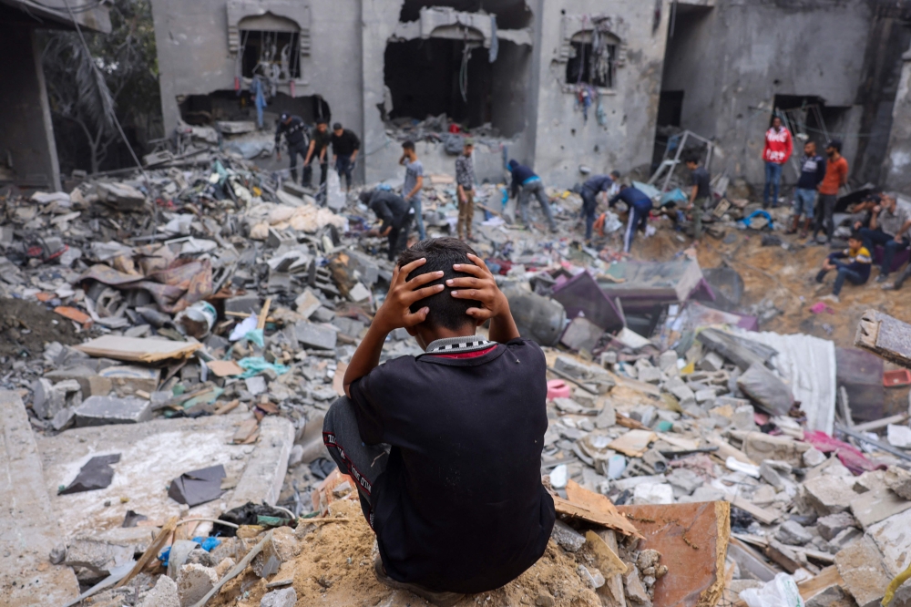 A child reacts as people salvage belongings from a damaged building following strikes on Rafah in the southern Gaza Strip, on November 12, 2023. Photo by Mohammed ABED / AFP